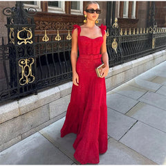 A woman twirling in a flowing red lace dress, showcasing its elegant design and movement.