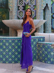 A woman posing in a stylish bodycon dress, highlighting the back slit and one-shoulder neckline.