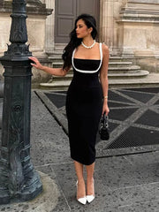 A woman  in a stylish midi dress, showcasing the pearl accents and flattering fit.