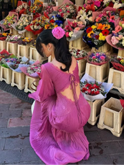 A woman twirling in a beautiful chiffon dress, showcasing its graceful movement and flattering silhouette.