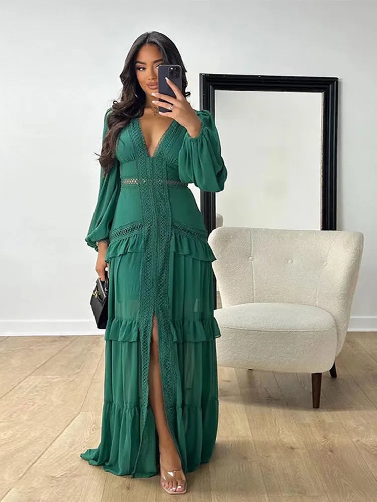 A woman wearing an elegant maxi dress with a flowing silhouette and ruffle details, highlighting the deep V-neck and long sleeves.