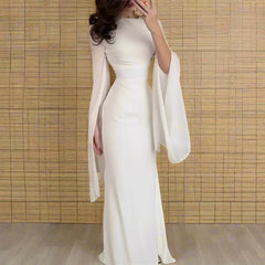 A woman wearing a luxurious full-length satin dress, showcasing its flattering silhouette and elegant drape.