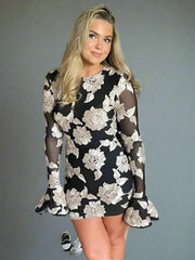 A woman smiling in a trendy floral mini dress, perfect for a party or special occasion.