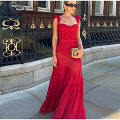 A woman twirling in a flowing red lace dress, showcasing its elegant design and movement.