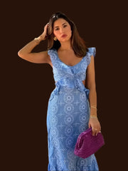 A woman wearing an elegant bohemian-inspired dress with a flowing silhouette and intricate embroidery details.