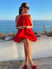 A woman twirling in a loose-fitting, red summer dress, showcasing its elegant movement and comfortable fit.